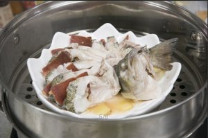 將鱸魚成花狀擺好，將火腿切片放入各縫隙中，放入鍋中隔水蒸12分鐘拿出，撒上蔥花即可。