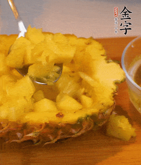 菠蘿對(duì)半切開(kāi)，切成小方格，用勺子把菠蘿肉挖出來(lái)。用鹽水稍浸泡。