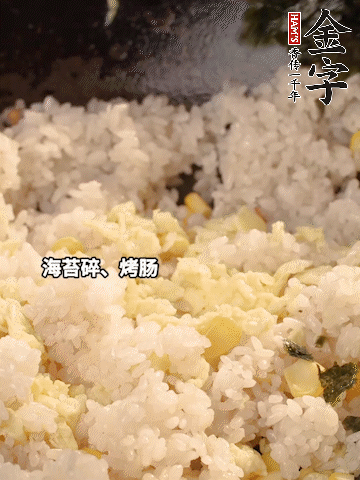 剩米飯下鍋炒散，依次下玉米粒、雞蛋、烤腸、海苔碎翻炒均勻。