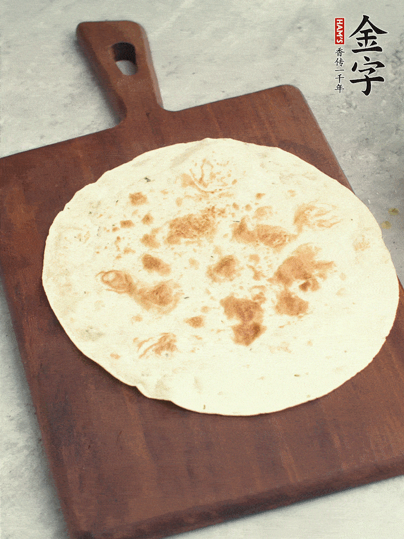 食材依次鋪在卷餅皮上，卷起來。