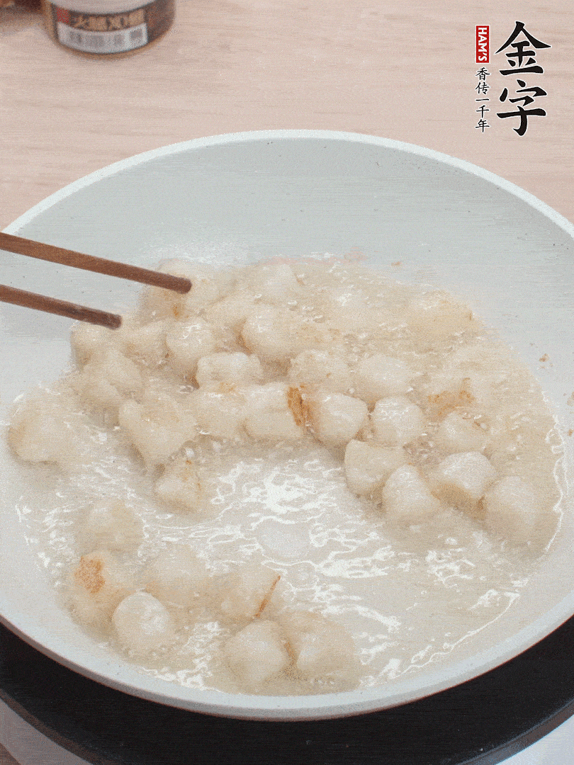 油溫4成熱，鮮貝蘸干淀粉下鍋煎，一面微黃后翻面。