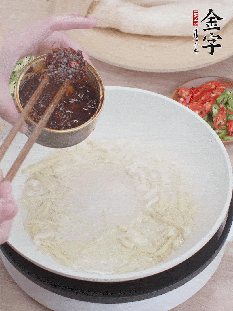 起鍋熱油，姜蒜、金字火腿干貝醬煸香。