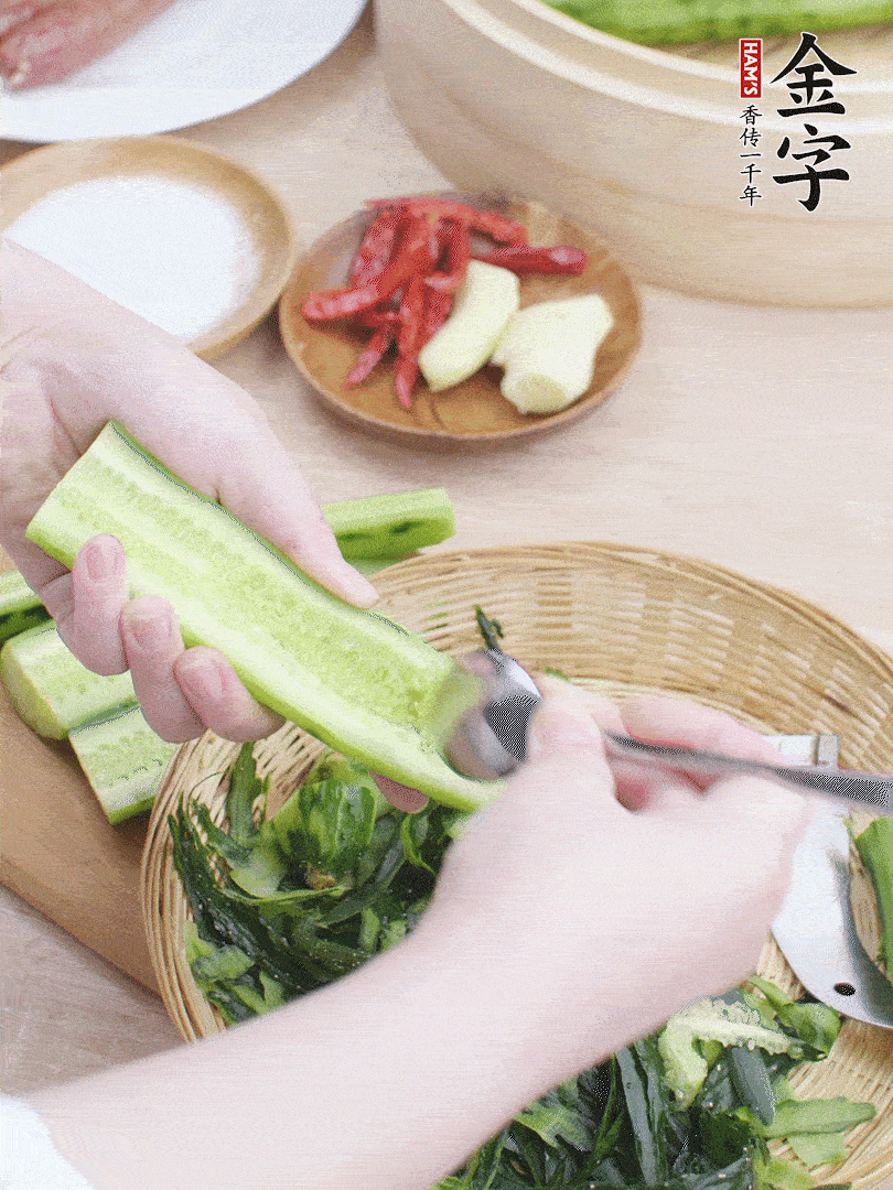 黃瓜削皮，對(duì)半切開，勺子挖去內(nèi)瓤，斜刀切片。青蒜斜刀切段。