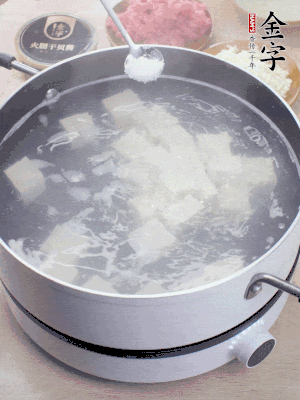豆腐切成大小均勻正方體，鍋內(nèi)放水，加一點鹽焯水10秒。