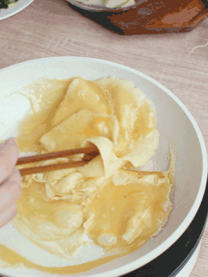 油6成熱時(shí)，下雞蛋液，邊緣凝固時(shí)翻拌成塊狀。