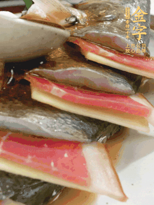 魚肚中塞蔥結(jié)、火腿片，魚身上碼放姜片、火腿片，倒入混合的料汁。