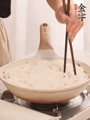把瀝干水分的米飯均勻鋪在上面，筷子戳幾個(gè)洞，以便透氣，轉(zhuǎn)小火蓋上蓋子燜至水分收干，大概10分鐘。